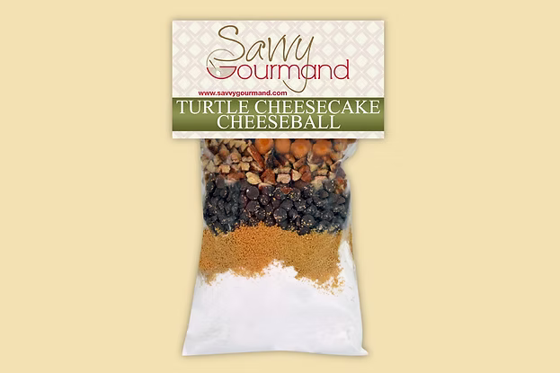 Savvy Gourmand turtle cheesecake cheeseball mix packaging on a beige background