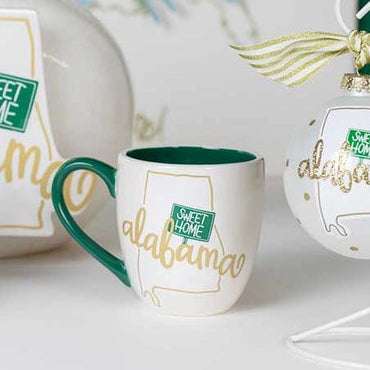 White ceramic items with 'Sweet Home Alabama' text on a white surface with a map in the background.