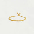 Gold bracelet on a light gray background