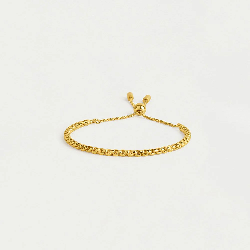 Gold bracelet on a light gray background