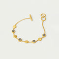 Gold bracelet with gray stones on a light gray background