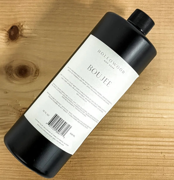 Black bottle with a label on a wooden surface