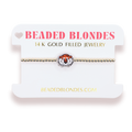 A gold beaded bracelet with a tiger head charm, displayed on a white branded card labeled 'BEADED BLONDES'.