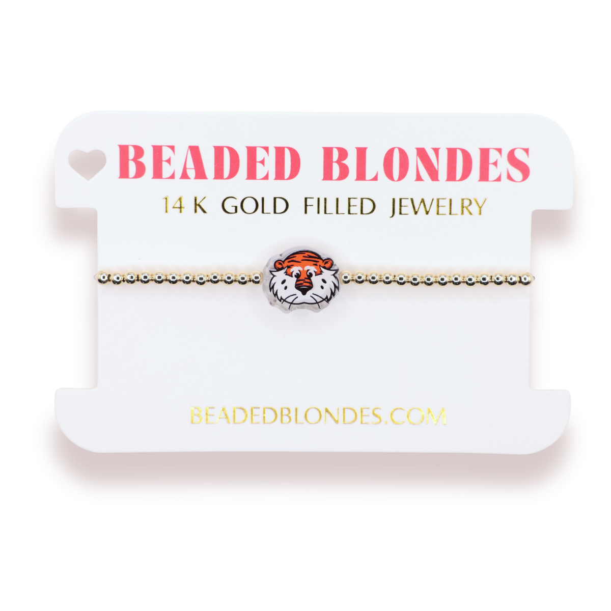 A gold beaded bracelet with a tiger head charm, displayed on a white branded card labeled 'BEADED BLONDES'.