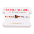 A beaded bracelet with orange, navy blue, and gold beads, featuring a central triangular 'Auburn' pennant charm, displayed on a white branded card labeled 'BEADED BLONDES'.