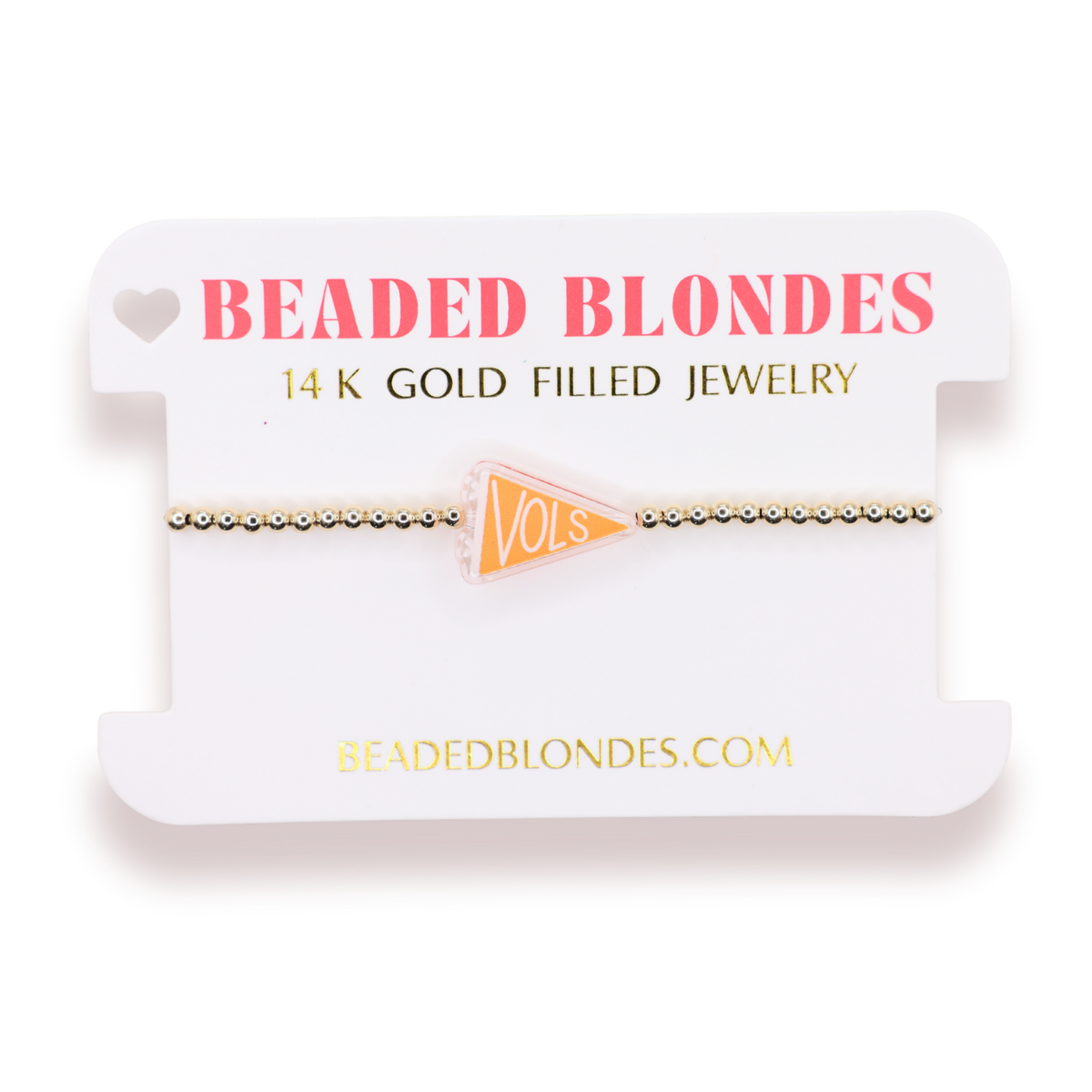 A gold beaded bracelet with a small orange triangular charm reading 'VOLS', displayed on a white branded card labeled 'BEADED BLONDES' and '14 K GOLD FILLED JEWELRY'.