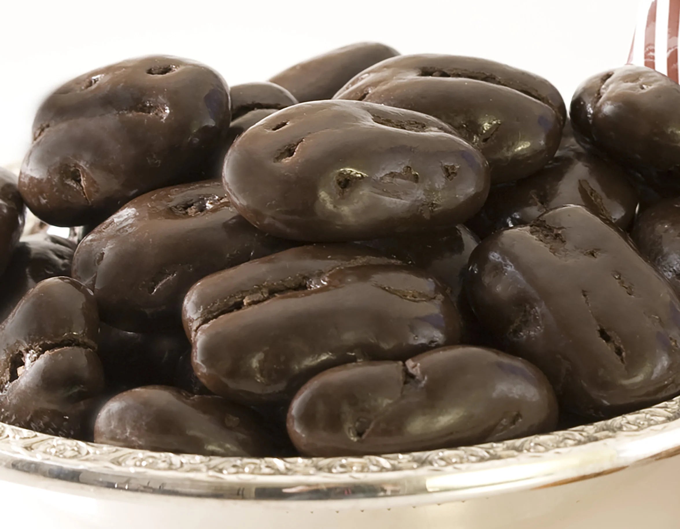Close-up of dark chocolate-covered pecans in a bowl