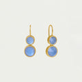 Gold earrings with blue stones on a light gray background