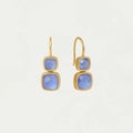 Gold earrings with blue gemstones on a light gray background
