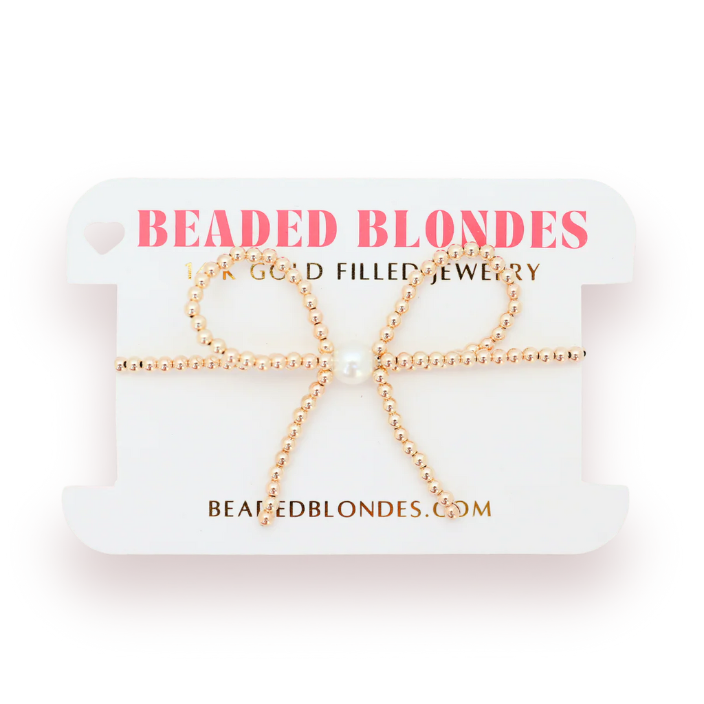 Gold beaded bow-shaped earrings on a 'Beaded Blondes' branded card.