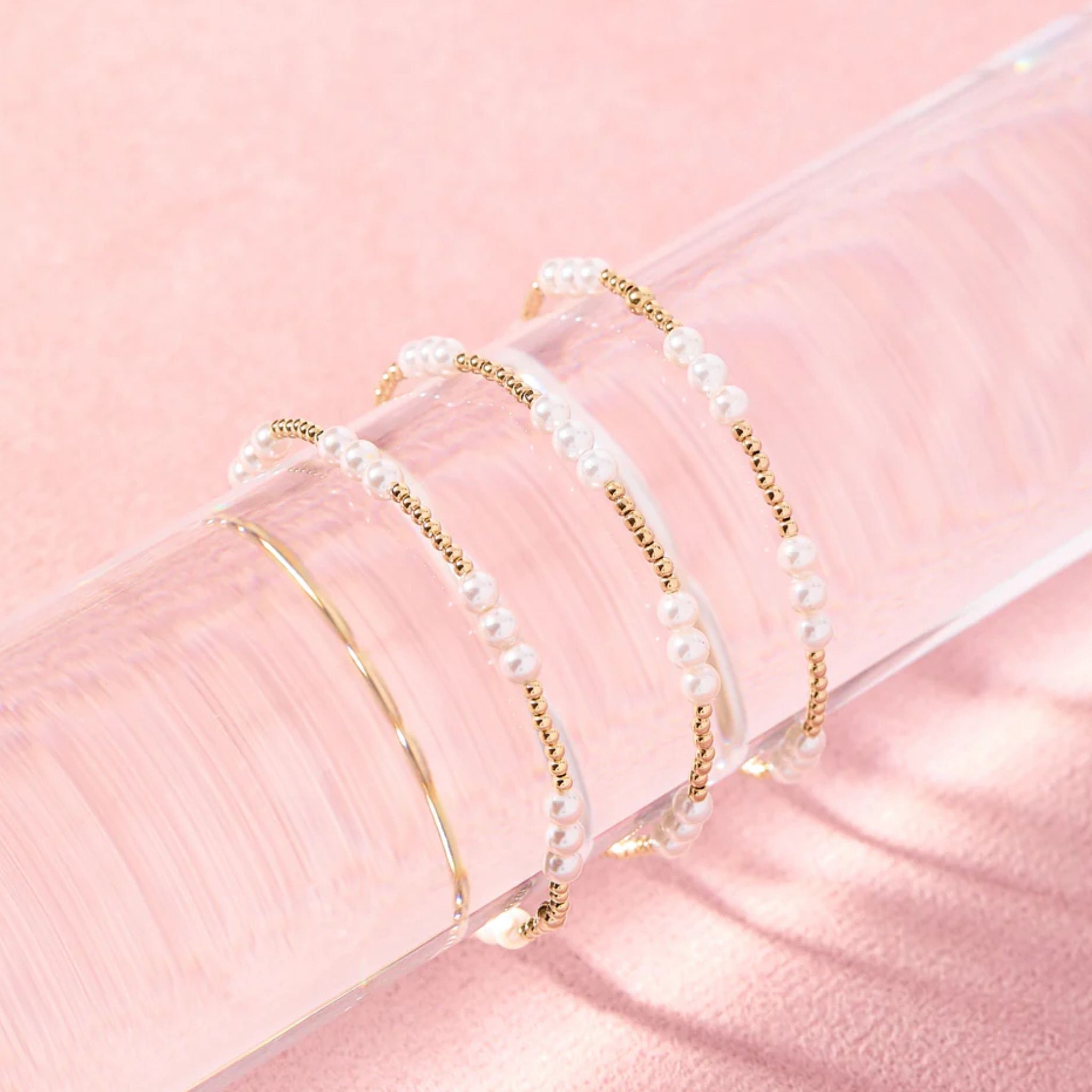 Set of pearl headbands on a pink background