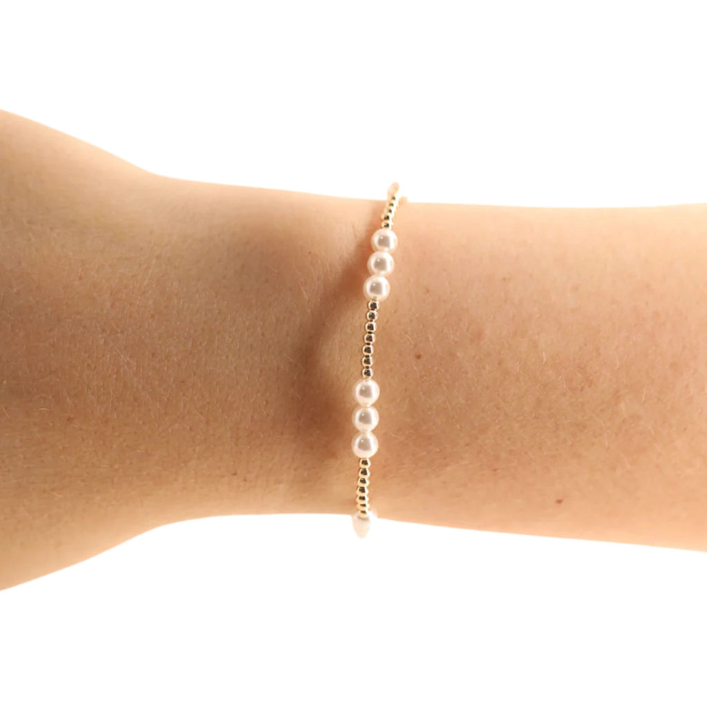 Pearl bracelet on a person's wrist against a white background