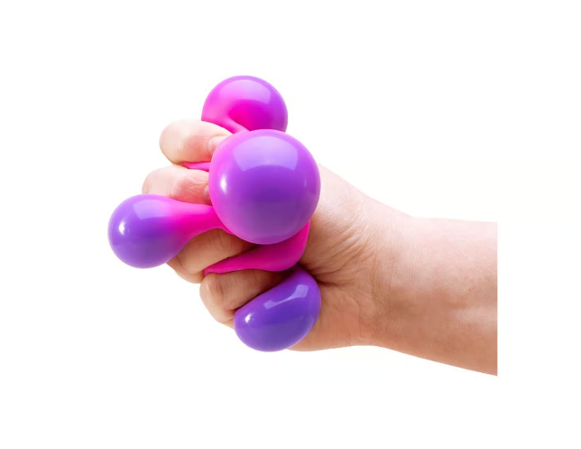 Hand holding a pink and purple fidgets/ stress ball against a white background