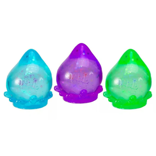 Three colorful NEEDOH GALACTIC GLOW DREAM DROP shaped like teardrops on a white background