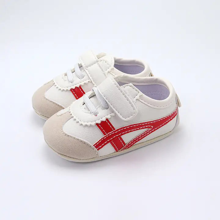 Off white infant tennis shoes with red accents and velcro closure for boys and girls