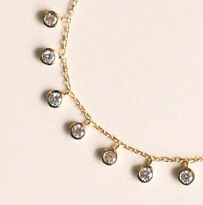 Necklace and bracelet set with gemstones on a beige background