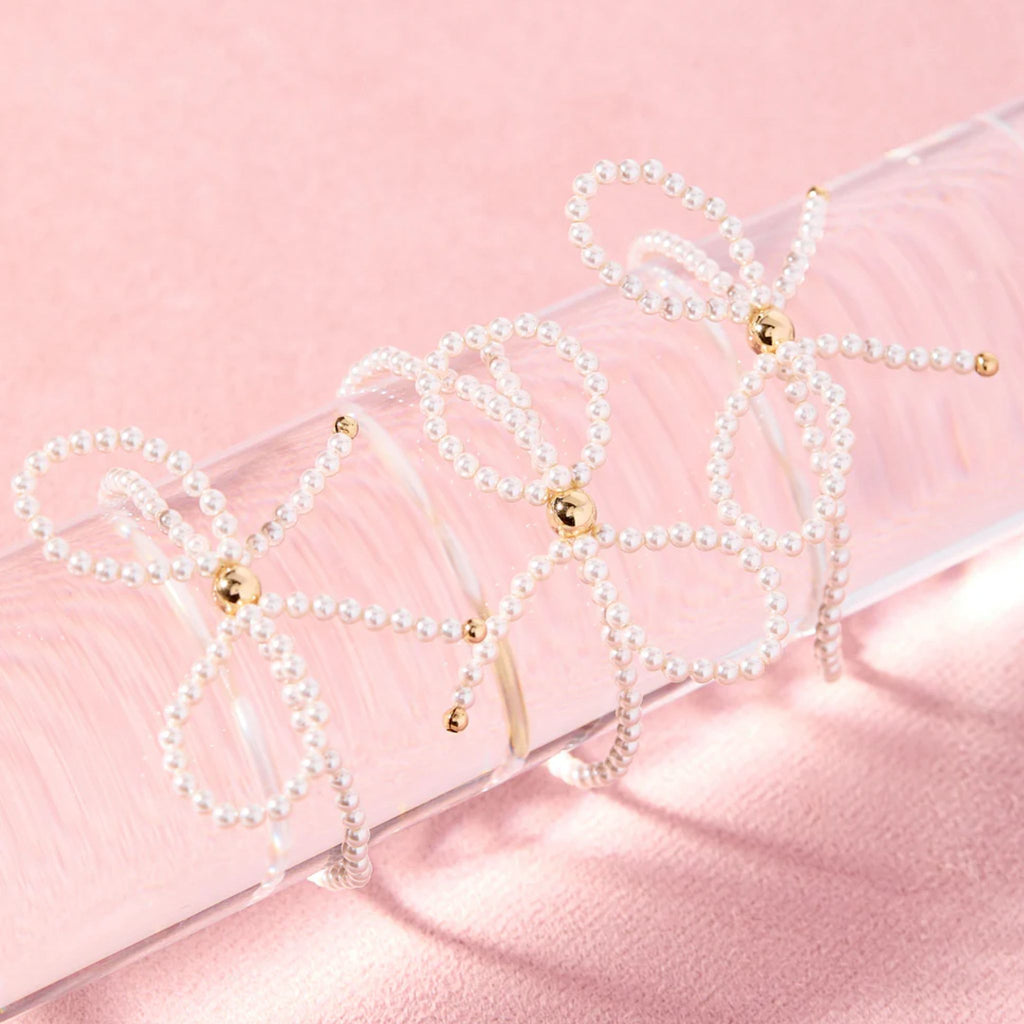 Pearl necklaces with gold accents on a pink satin surface