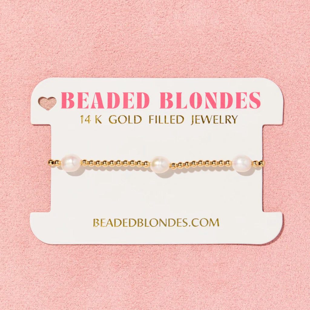 Pearl bracelet on a 'Beaded Blondes' branded card with pink background
