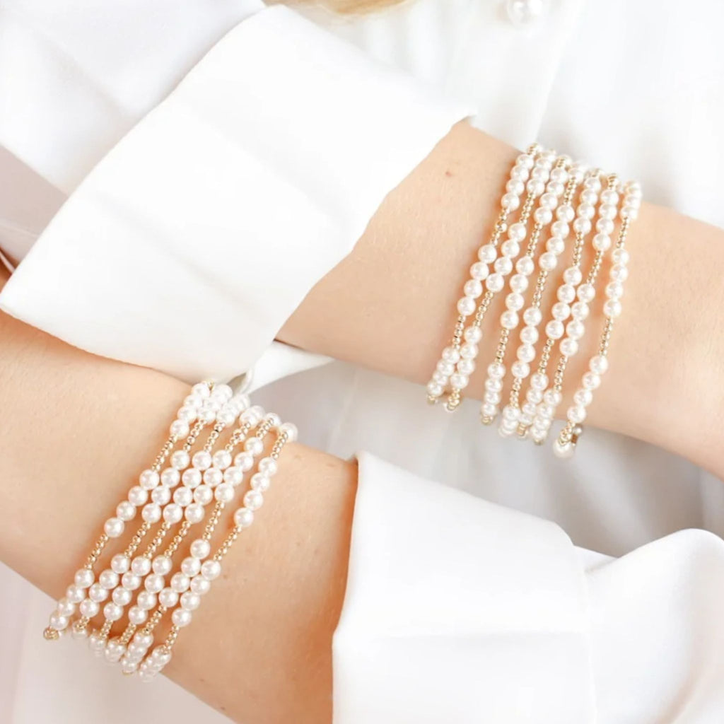 Two arms wearing multiple Scottie Bracelet in Gold on a white background