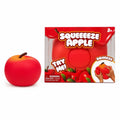 A red squishy apple toy shown next to its retail packaging box on a clean white background. The box features the text 'SQUEEEZE APPLE' and includes a demonstration graphic of a hand squeezing the apple.